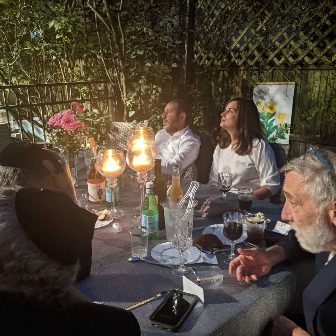 Guests gathered around the dinner table by candlelight
