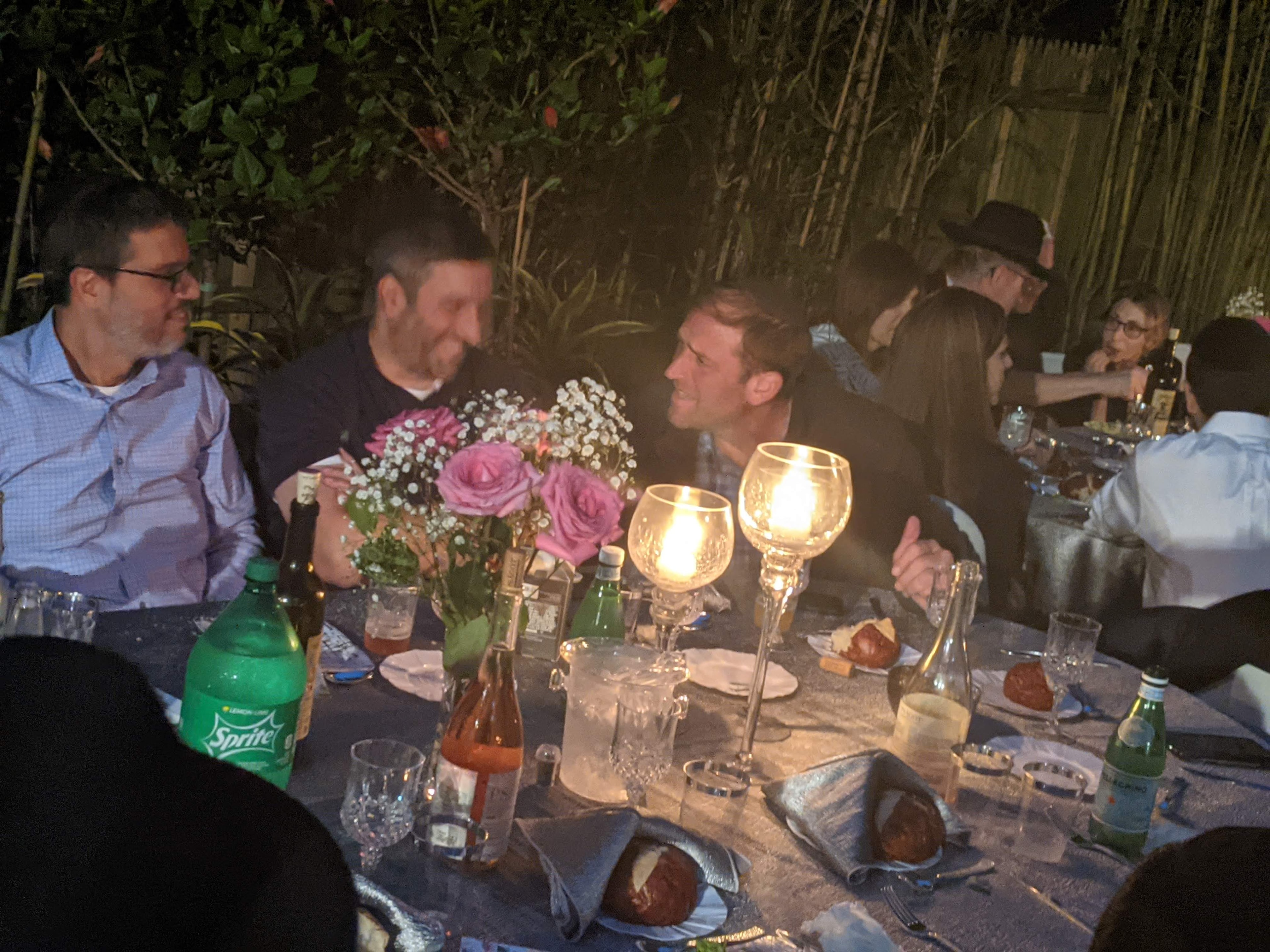 Guests in conversation at the candlelit dinner table