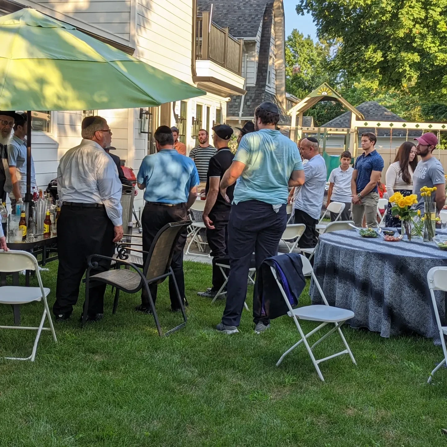 Guests mingling on the lawn at the 2022 Arizal Dinner at the Agin home