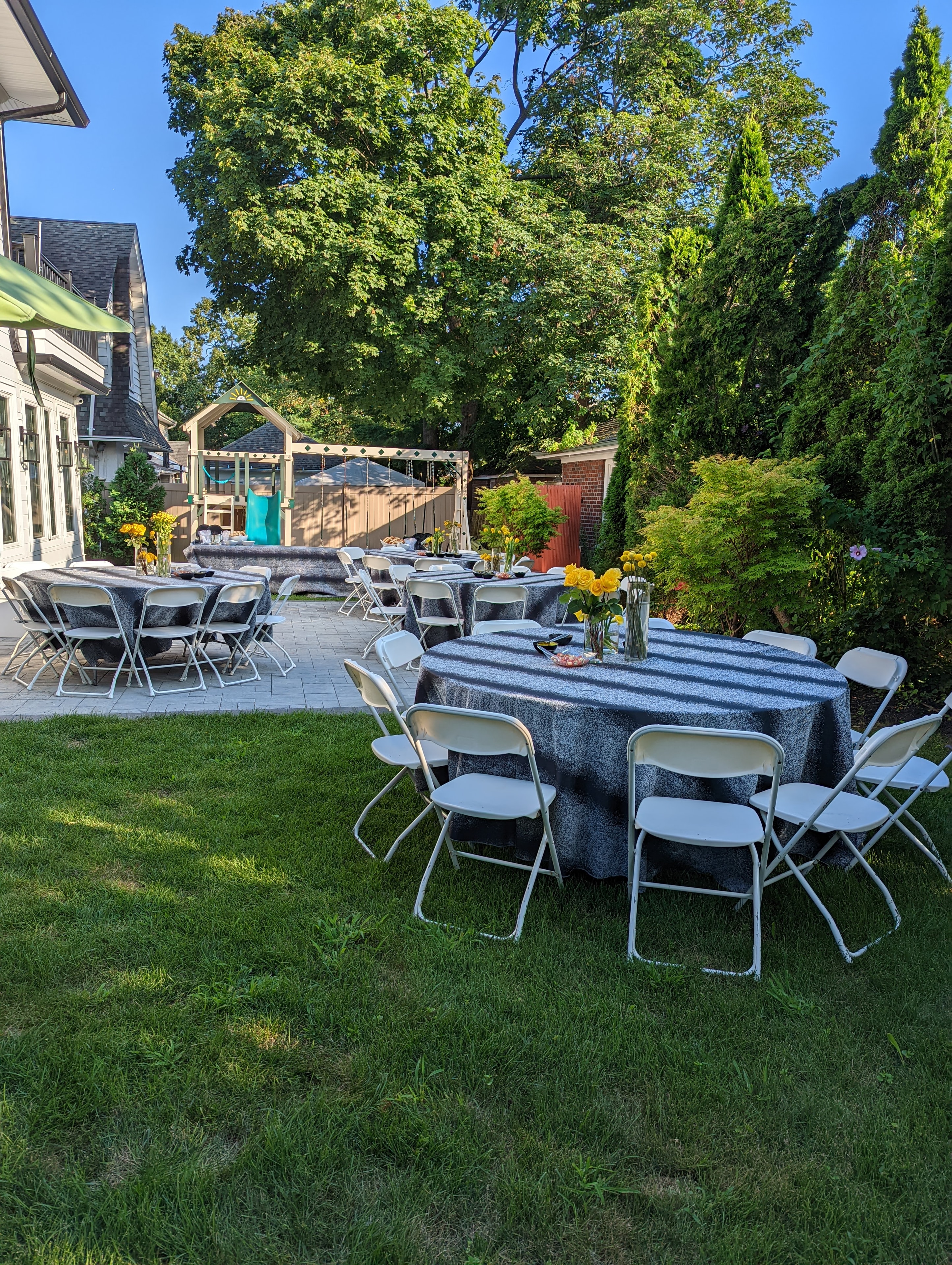 Beautifully set backyard tables with yellow roses at the 2022 Arizal Dinner